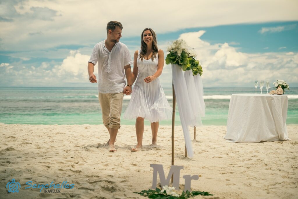 Az ifjú pár a bevonuló folyosó mellett sétál a ceremónia után, Baie Lazare tengerparton.