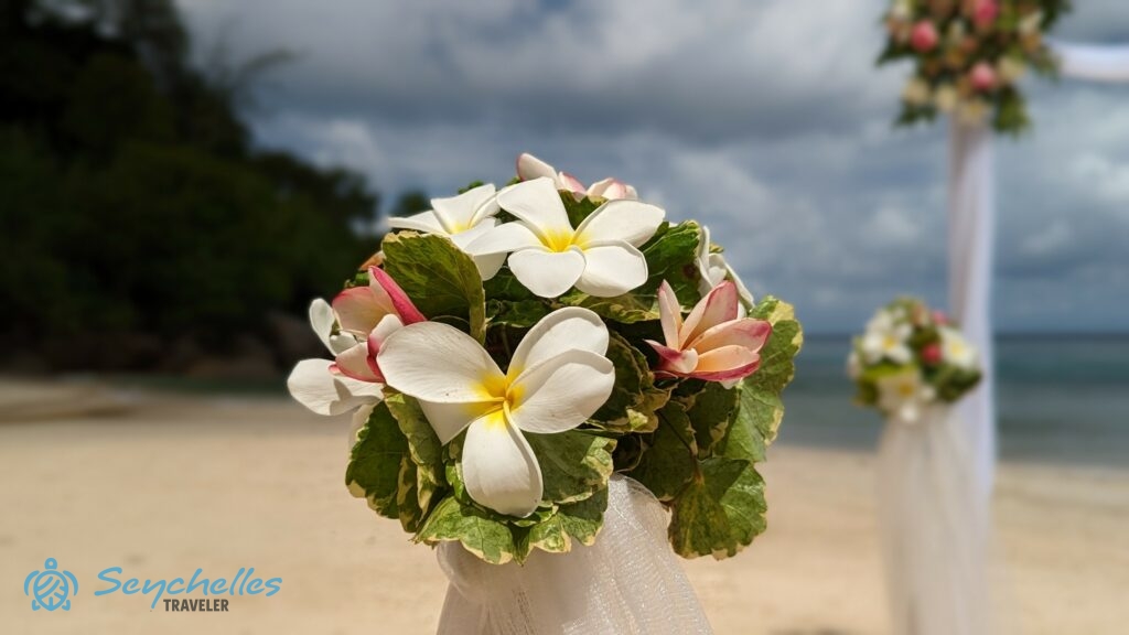 Levelekből és különböző méretű frangipánikból készült oszlopdísz, Anse Louis tengerparti esküvőn.