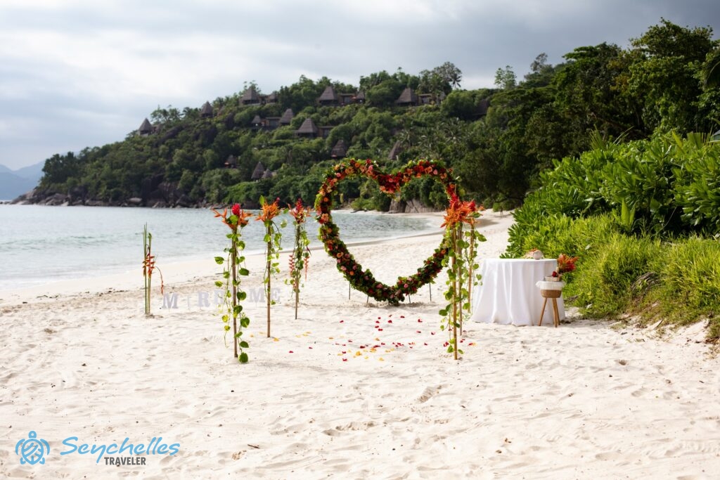 Szív alakú, virágokkal körbefont boldogságkapu és hat oszlopból álló bevonuló folyosó Anse Louis tengerparton.
