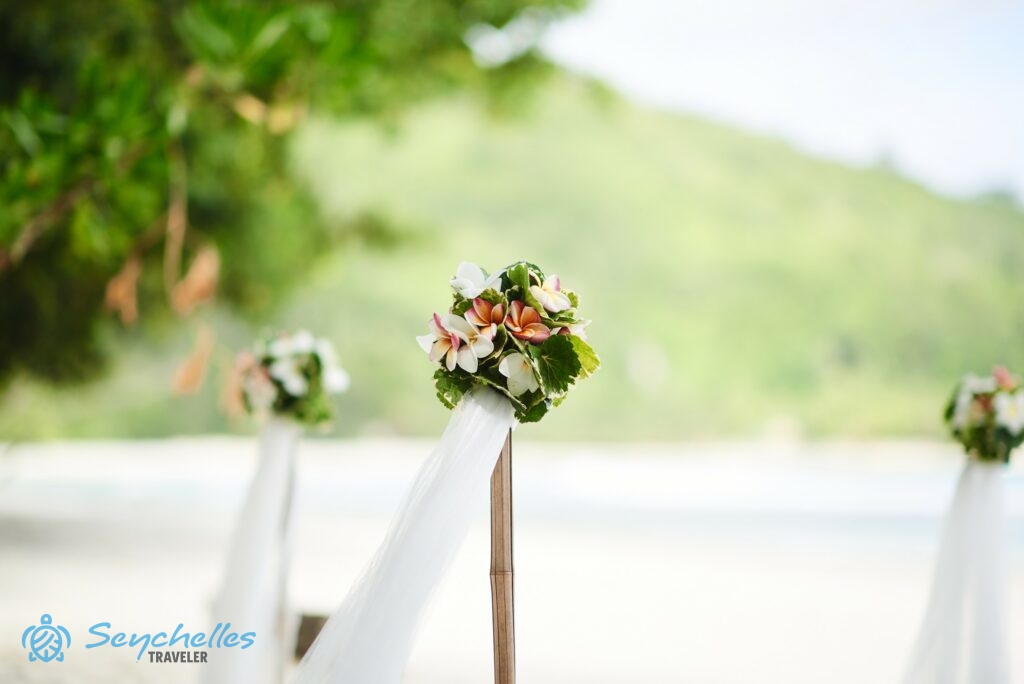 Frangipáni virágokból és levelekből készült, gömb alakú bambusz oszlop dísz tengerparti esküvőn, Baie Lazare öbölben.