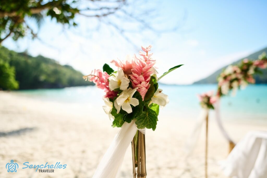 Fehér frangipáni és rózsaszín gyömbér virágokból, zöld levelekből készült bevonuló folyosó dekoráció Port Launay öbölnél.