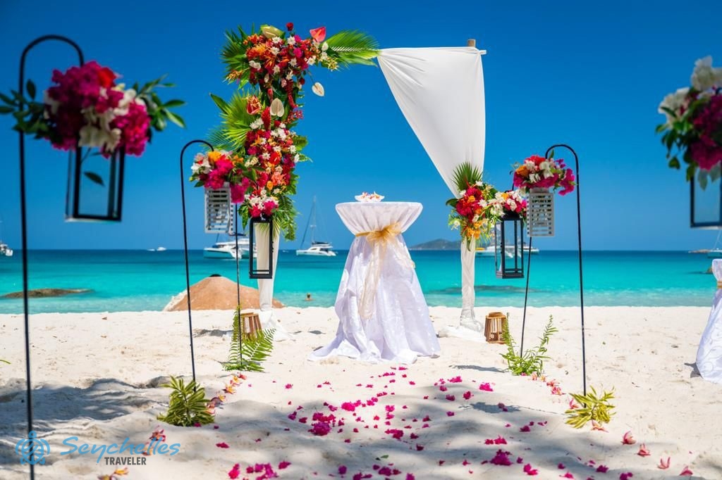 Színes virágokkal és fehér muszlinnal díszített boldogságkapu, és a szirmokkal szórt bevonuló folyosó Praslin-en.