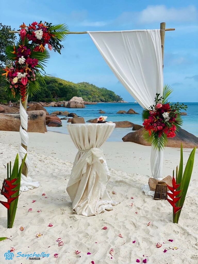 Szögletes boldogságkapu virág és muszlin dekorral, esküvői asztal és virágokból készült bevonuló folyosó Praslin-en.