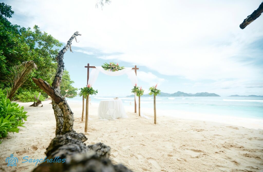 Boldogságkapu előtte feldíszített négy oszloppal és esküvői asztal Anse Severe tengerparton.