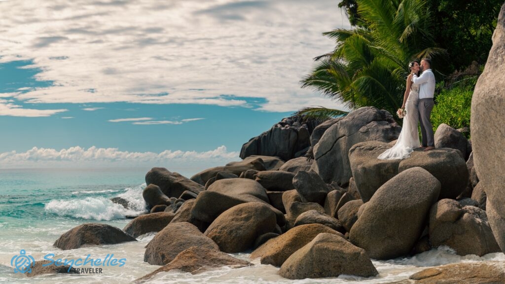 Az ifjú pár Anse Georgette esküvő helyszín tengerparti szikláin áll Praslin-en.
