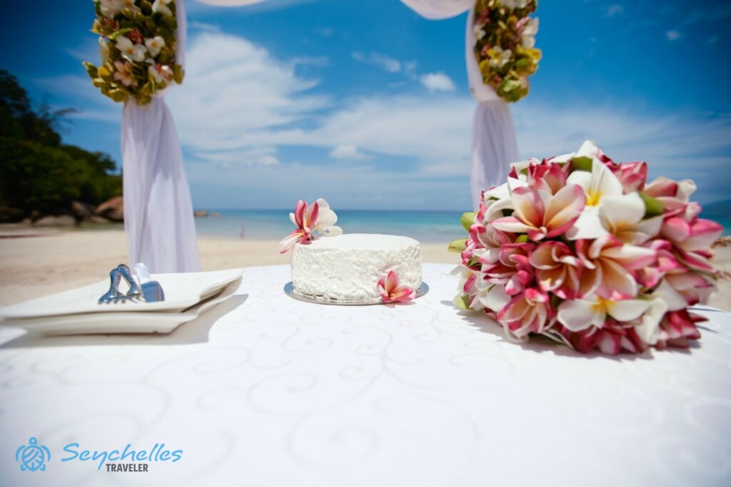 Rózsaszín és fehér frangipániból álló menyasszonyi csokor, vele harmonizáló tortával.