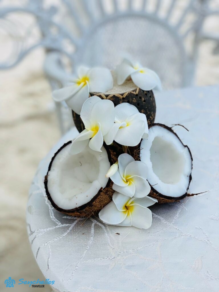 Két fél kókuszból készült gyűrűtartó fehér frangipáni virágokkal Praslin-en.