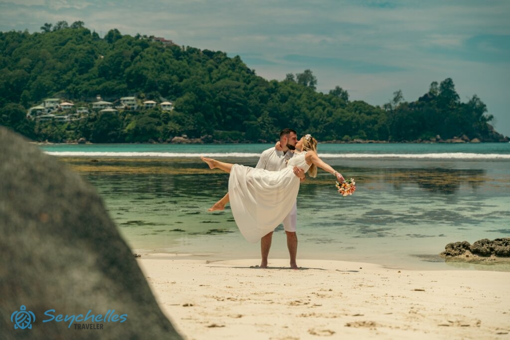 Az újdonsült férj a karjaiban tartja kedvesét Baie Lazare tengerparton, Mahén.