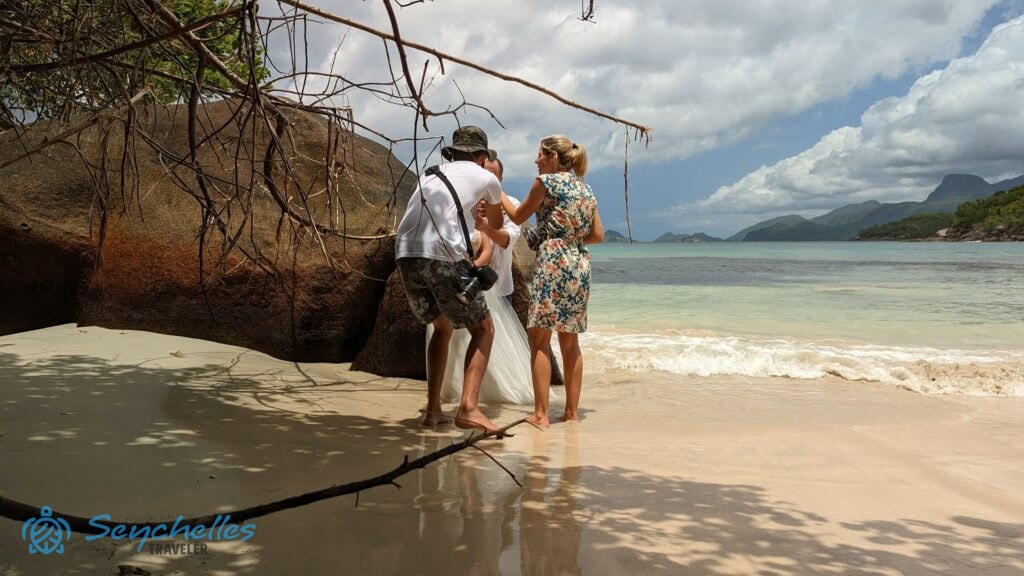 Réka tolmácsolja az esküvői fotós beállításra vonatkozó kéréseit a párnak Anse Louis tengerparton.