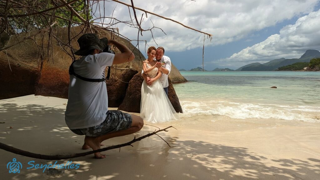 Esküvői fotózás Anse Louis tengerparton a képen a friss házasok és a fényképész.