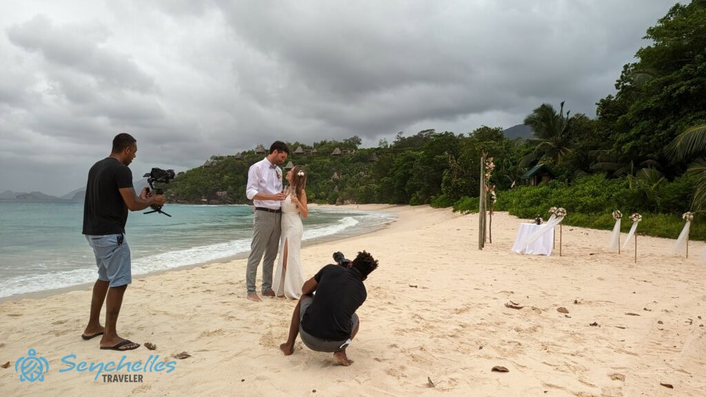 Az Anse Louis homokos partján álló házaspárt pezsgőspohárral a kezükben fotózzák.