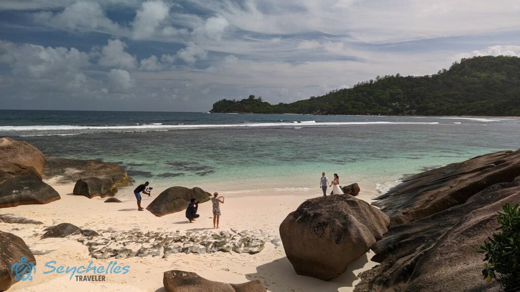 Egy szikla tetejéről készült kép a Baie Lazare tengerparton zajló esküvői fotózásról.
