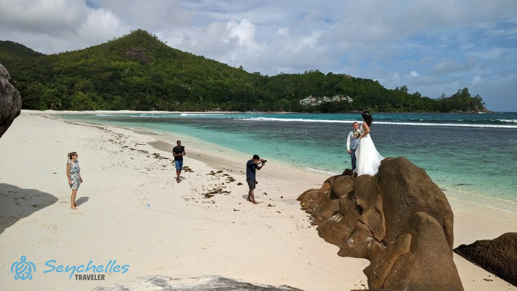 Látványkép az esküvői fotózásról a sziklán álló párral Baie Lazare tengerparton.
