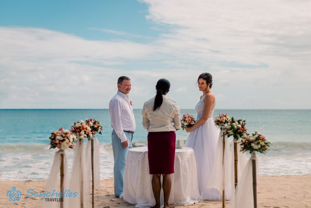 Az angol nyelvű szertartásvezető előtt, szimbolikus esküvőn tesz egymásnak fogadalmat egy pár Anse Louis tengerparton.