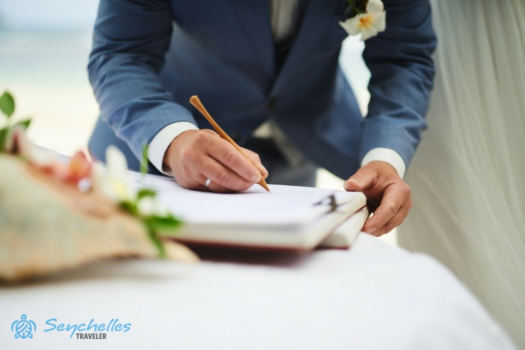 A vőlegény magyar nyelvű hivatalos esküvőn írja alá a házassági anyakönyvet Baie Lazare parton.