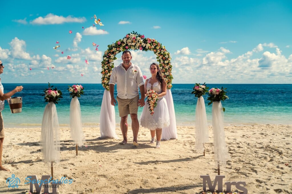 Réka rózsaszirmokat szór a fiatal pár elé Baie Lazare tengerparton a magyar hivatalos esküvőt követően.