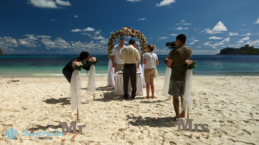 Az anyakönyvvezető és Réka celebrálja a magyar hivatalos esküvőt Baie Lazare tengerparton.