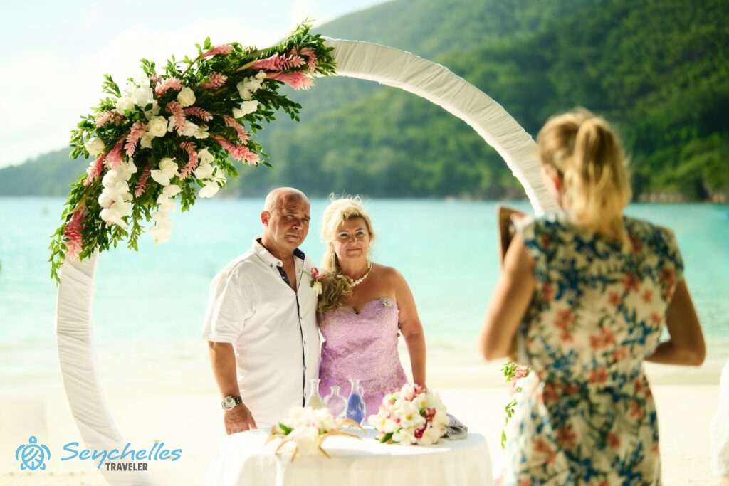 Port Launay tengerparton Réka magyar nyelvű, hivatalos esküvőn mondja beszédét a feldíszített kapu alatt álló párnak.