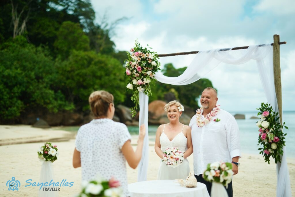 Réka a magyar nyelvű szimbolikus esküvői beszédét mondja Anse Louis tengerparton a párnak.