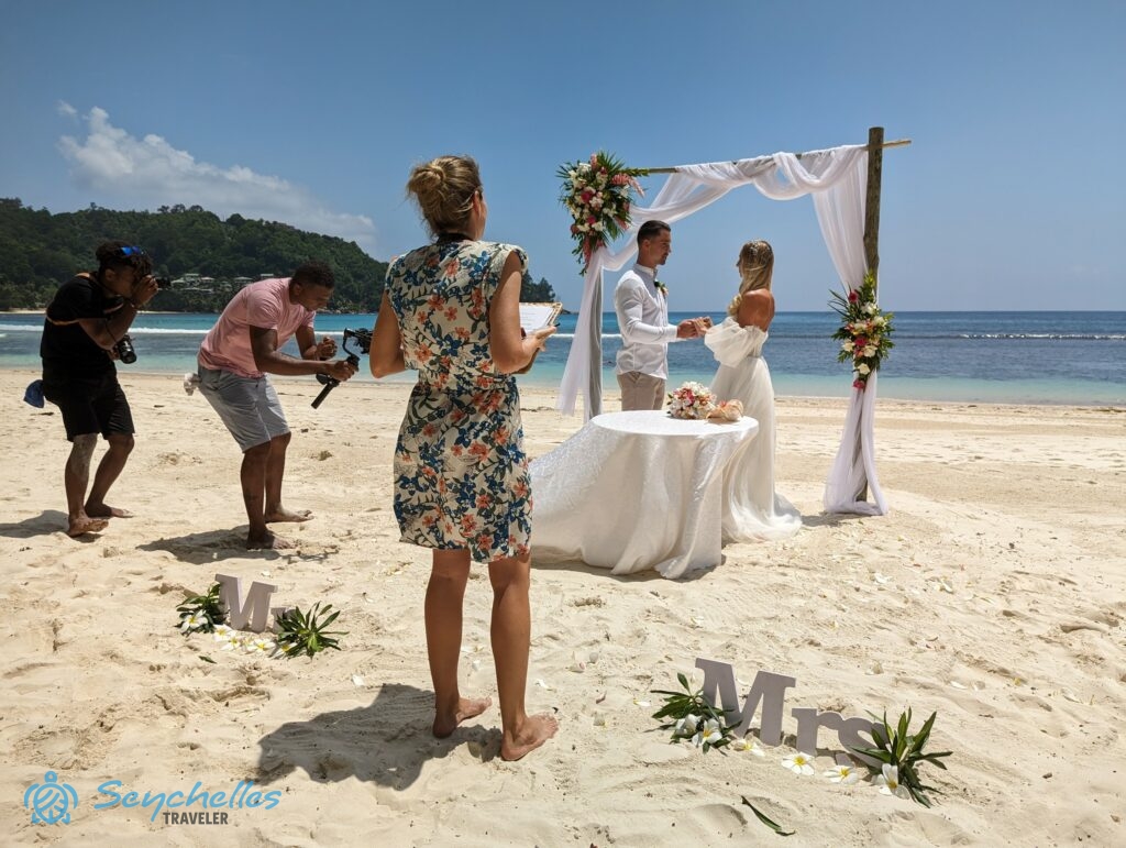 Réka a fiatal párral és a fotósokkal Baie Lazare parton egy magyar nyelvű szimbolikus esküvőn.