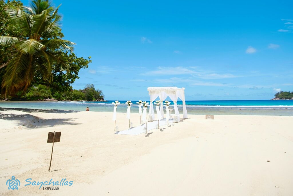 Hófehér, hat oszlopból álló bevonuló folyosó és esküvői pavilon Baie Lazare tengerparton.