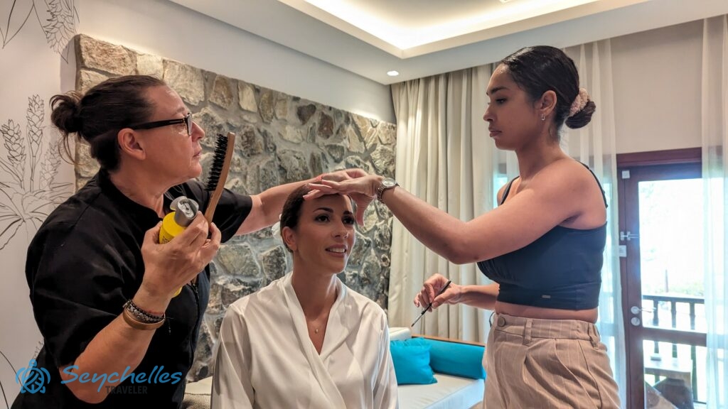 A fodrász és a sminkes előkészítik a menyasszonyt az esküvőre.