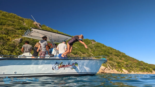 Egy lány vízbe ugráshoz készülődik a Simplicity hajón Félicité-szigetnél.