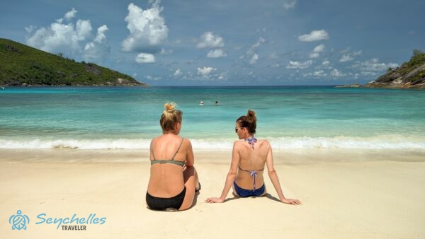 A hajó vendégei a parton ülve és a vízben fürdőzve.