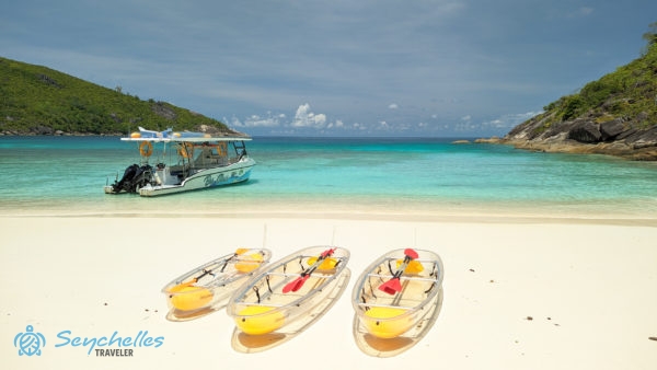 Átlátszó kajakok Anse du Riz parton, háttérben az üvegfenekű hajóval.