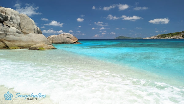 Átlátszó türkizkék óceán és gránitsziklák Cocos-sziget partjánál.