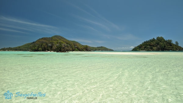 Round, Sainte Anne és Moyenne szigetek a homokpadot körülvevő sekély, átlátszó vízből fényképezve.