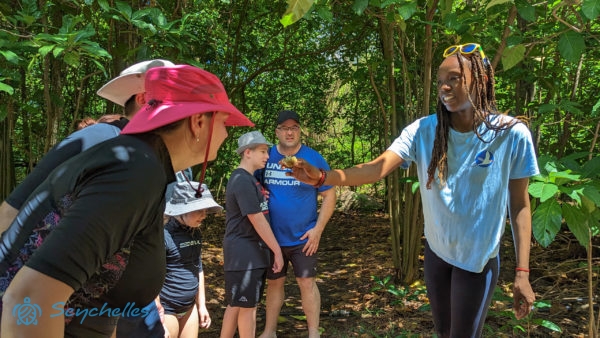 A túravezető noni termést mutat a látogatóknak Aride-szigeten.