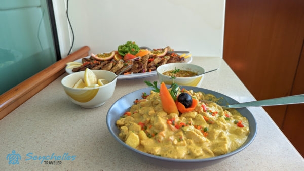 Ízletes fogások az ebédhez tálalva a katamarán szalonjában Curieuse szigetnél.