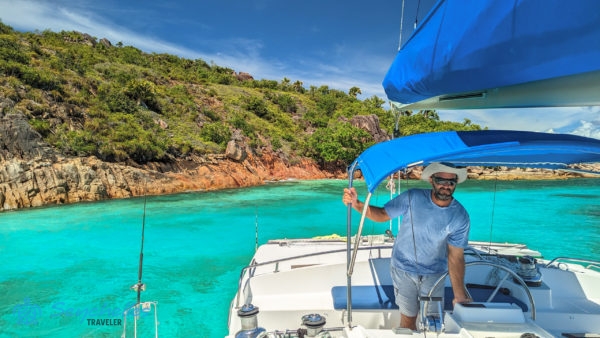 A katamaránt a kapitány Pointe Caimant sziklás partjánál kormányozza Curieuse szigetnél.