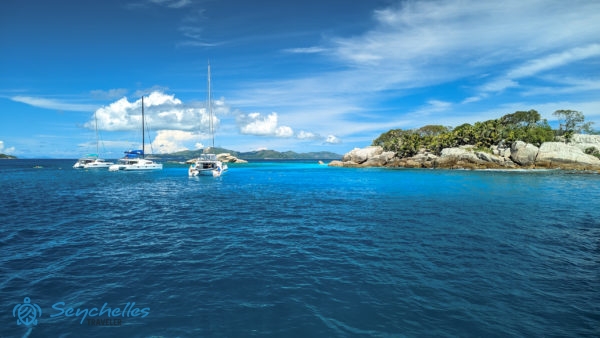 Katamaránok horgonyoznak Cocos sziget jellegzetes sziklás partja közelében.